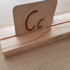 Natural timber stand with letter C standing in it on timber background