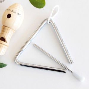 Mini triangle instrument on white background with mini whistle and leaves